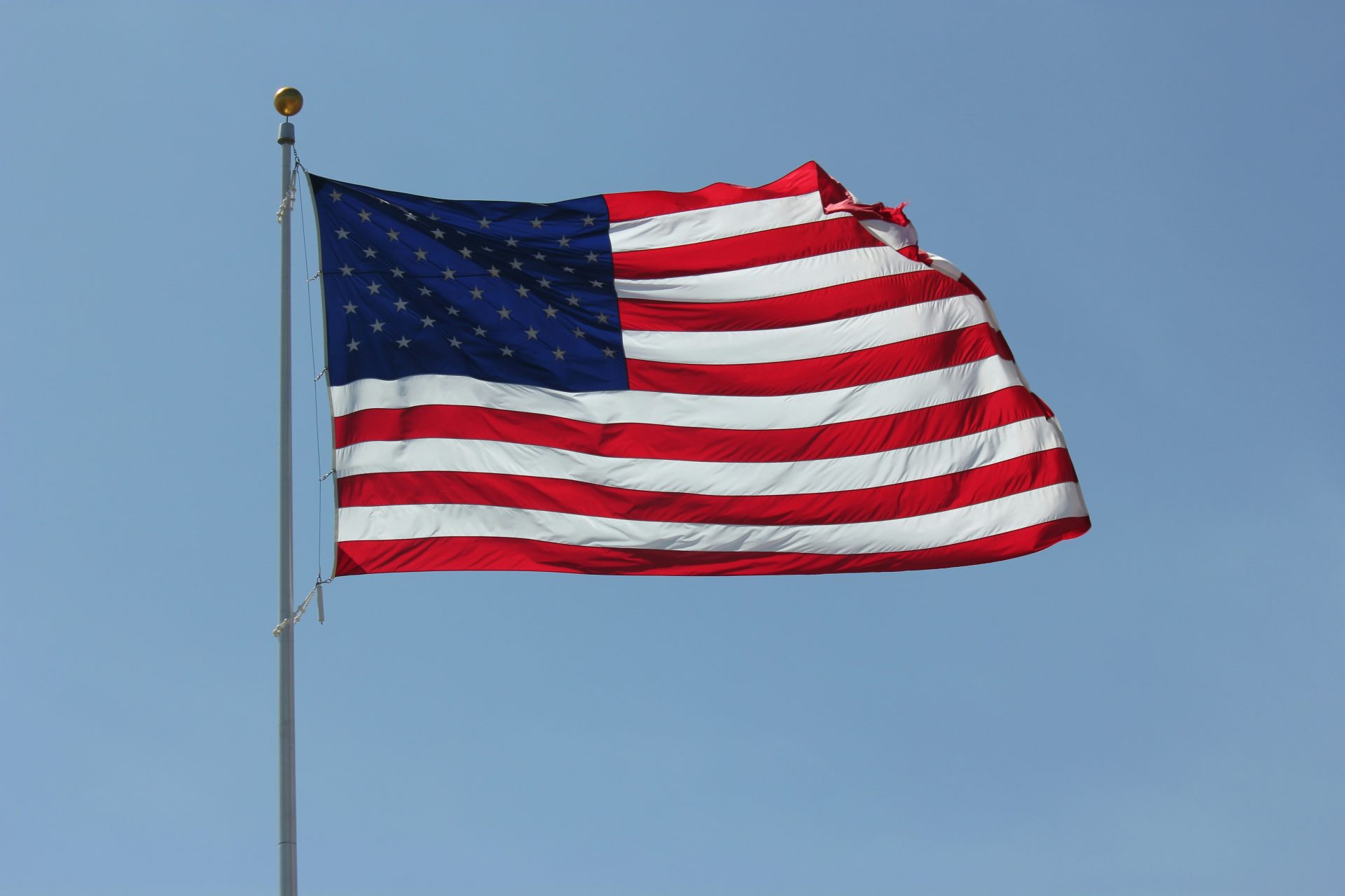 a large american flag flying in the sky